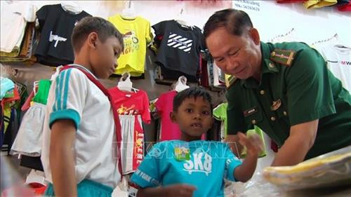 Thiếu tá Nguyễn Văn Long, Đồn Biên phòng Kà Tum với các trẻ nhỏ được nhận làm con nuôi của Đồn. Ảnh: Thanh Tân-TTXVN Thiếu tá Nguyễn Văn Long, Đồn Biên phòng Kà Tum với các trẻ nhỏ được nhận làm con nuôi của Đồn. Ảnh: Thanh Tân-TTXVN