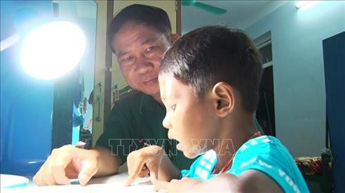 Thiếu tá Nguyễn Văn Long, Đồn Biên phòng Kà Tum dạy học cho các trẻ nhỏ được nhận làm con nuôi của Đồn. Ảnh: Thanh Tân-TTXVN Thiếu tá Nguyễn Văn Long, Đồn Biên phòng Kà Tum dạy học cho các trẻ nhỏ được nhận làm con nuôi của Đồn. Ảnh: Thanh Tân-TTXVN