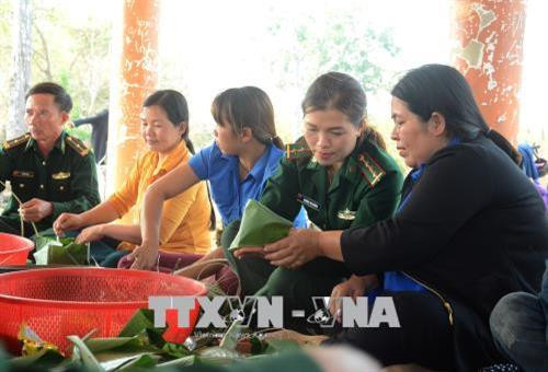 Các thành viên Bộ đội biên phòng, Hội Liên hiệp phụ nữ và Đoàn Thanh niên tỉnh Gia Lai gói bánh chưng tặng bà con vùng biên giới Ia Mơ. Ảnh: Hoài Nam – TTXVN