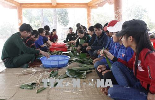 Các thành viên Bộ đội biên phòng, Hội Liên hiệp phụ nữ và Đoàn Thanh niên tỉnh Gia Lai gói bánh chưng tặng bà con vùng biên giới Ia Mơ. Ảnh: Hoài Nam – TTXVN