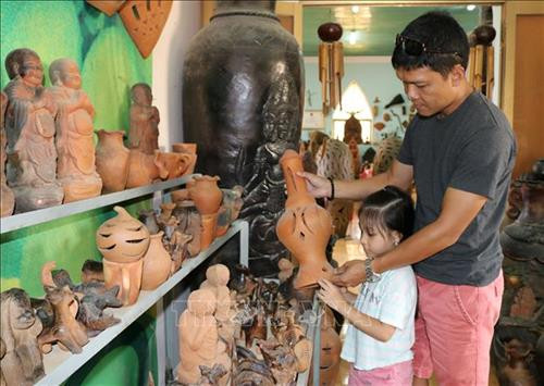 Du khách lựa chọn sản phẩm gốm Bàu Trúc. Ảnh: Nguyễn Thành – TTXVN Du khách lựa chọn sản phẩm gốm Bàu Trúc. Ảnh: Nguyễn Thành – TTXVN