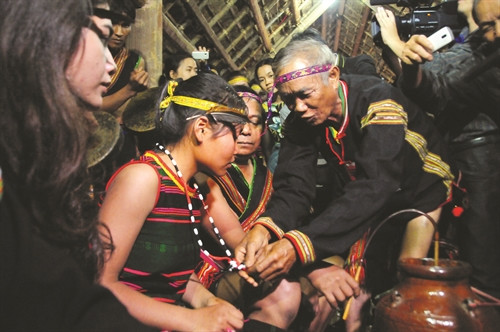 Sau nghi thức cúng cầu sức khỏe, thầy cúng lấy vòng đồng đeo vào tay từng người và đeo chuỗi hạt cho phụ nữ