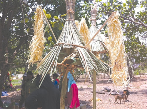 Cây tre và chòm lá hình chiếc dù, biểu tượng cho ngôi nhà dành cho các vị thần về dự lễ.