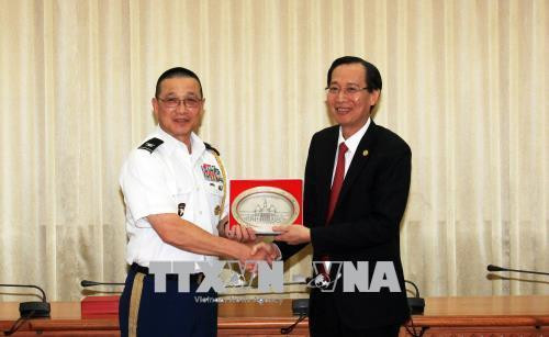 Ông Lê Thanh Liêm, Phó Chủ tịch Thường trực Ủy ban nhân dân Thành phố Hồ Chí Minh tặng quà lưu niệm cho trưởng đoàn Tùy viên quân sự các nước tại Việt Nam, Đại tá Tôn Thất Tuấn, Tùy viên quốc phòng Hoa Kỳ tại Việt Nam (trái). Ảnh: Xuân Khu-TTXVN