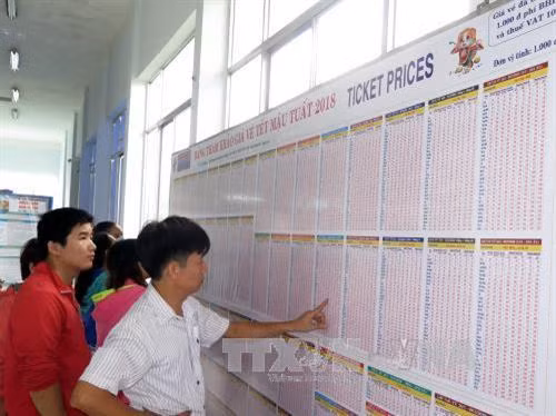 Hành khách đến xem thông tin vé tàu Tết 2018 tại ga Sài Gòn. Ảnh: Hoàng Hải-TTXVN