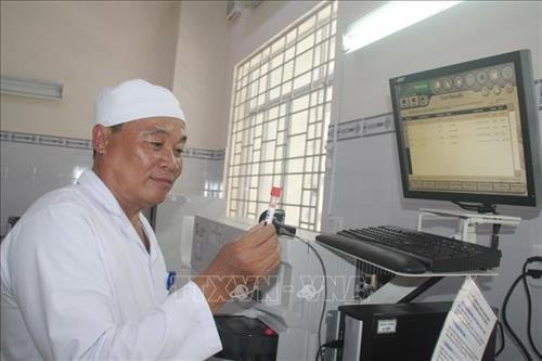 Bác sĩ Hồ Văn Thúc đang làm việc phòng xét máu, Bệnh viện đa khoa khu vực Long Khánh. Ảnh: Lê Xuân-TTXVN