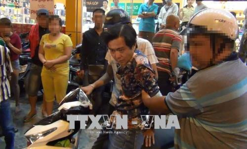 Các trinh sát bắt quả tang đối tượng nhận ma túy đi giao. Ảnh: TTXVN phát