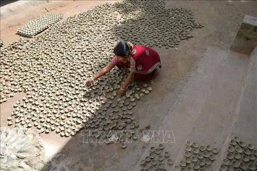 Người dân làm đèn dầu đất nung chuẩn bị cho lễ hội Diwali. Ảnh: THX/ TTXVN Người dân làm đèn dầu đất nung chuẩn bị cho lễ hội Diwali. Ảnh: THX/ TTXVN