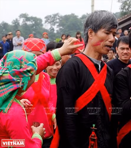 Sợi dây hồng cùng bàn lễ bày ngay trước cửa nhà gái để chuẩn bị đón nhà trai sang rước dâu. Rượu, nước lã và mấy cái chén làm bằng thân tre đặt trên bàn lễ. Nhà trai trên đường đi tới nhà gái đón dâu. Đội pí lè trong đoàn đón dâu của nhà trai. Đoàn rước dâu vừa đi vừa nổi nhạc thể hiện niềm vui mừng. Nhà gái hát đối khi nhà trai tới đón dâu Nhà trai hát đối lại. Gia đình nhà gái bôi phẩm đỏ lên mặt các thành viên trong đoàn nhà trai. Nhà trai trao lễ vật ngày cưới cho nhà gái.