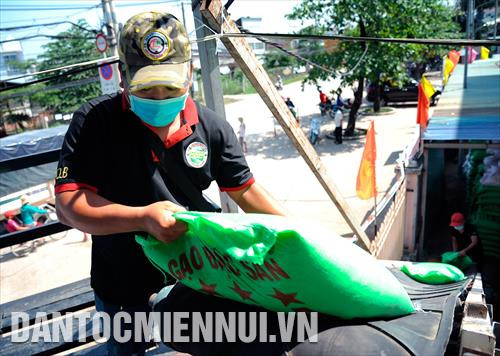 Các tình nguyện viên vận chuyển gạo bằng băng chuyền để bỏ vào thùng gạo của máy "ATM gạo"