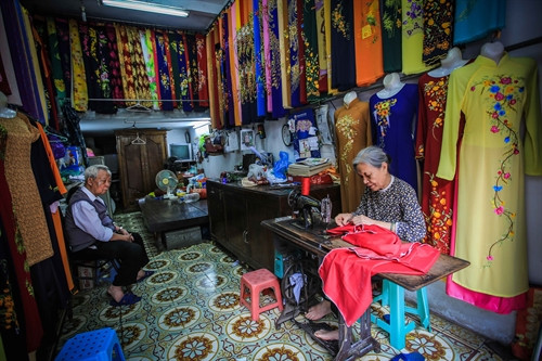Bà Lê Thị Quyến, chủ hiệu áo dài Vinh Trạch ở phố Lương Văn Can, quận Hoàn Kiếm dù tuổi cao nhưng vẫn miệt mài bên bàn máy để trực tiếp làm ra những sản phẩm áo dài mang đúng thương hiệu của Trạch Xá. Bà Lê Thị Quyến, chủ hiệu áo dài Vinh Trạch ở phố Lương Văn Can, quận Hoàn Kiếm dù tuổi cao nhưng vẫn miệt mài bên bàn máy để trực tiếp làm ra những sản phẩm áo dài mang đúng thương hiệu của Trạch Xá.