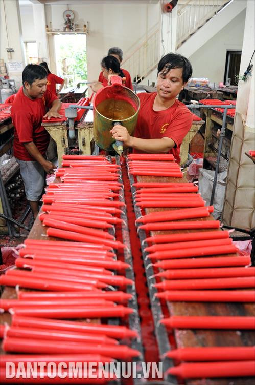 Cơ sở sản xuất đèn cầy Vĩnh Hưng, phường Châu Phú B (Châu Đốc, An Giang) là cơ sở tiên phong trong ngành sản xuất đèn cầy (nến) với các mẫu đèn pháo, cá kim long ngư, đèn ly, đèn hoa sen…; mỗi tháng, cung cấp ra thị trường khoảng 10 tấn sản phẩm các loại, tạo việc làm, thu nhập ổn định cho nhiều lao động tại địa phương. Trong ảnh: Một công đoạn sản xuất đèn cầy (nến) tại cơ sở Vĩnh Hưng