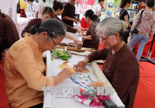 Những người lâu năm trong nghề thêu. Ảnh: Ninh Đức Phương - TTXVN