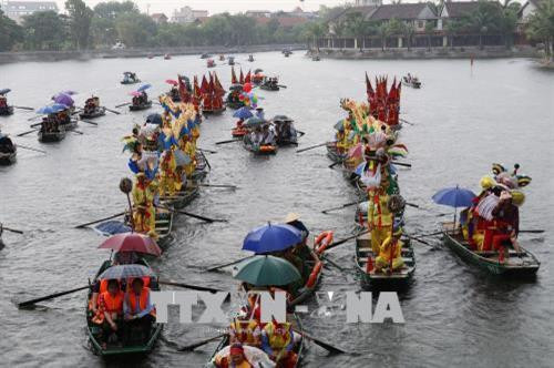 Lễ rước thuyền rồng trên sông Ngô Đồng. Ảnh: Ninh Đức Phương - TTXVN