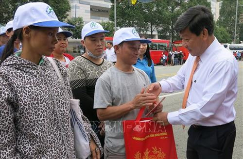 Ông Trần Thanh Liêm, Chủ tịch UBND tỉnh Bình Dương, động viên, tặng quà các công nhân về quê ăn Tết. Ảnh: Hải Âu-TTXVN