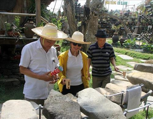 Du khách vẫn thoải mái với trải nghiệm đàn đá. Ảnh: Xuân Triệu - TTXVN