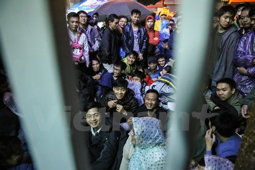 3 giờ sáng nhưng rất nhiều phụ huynh đã đứng chờ trước cổng phòng tiêm chủng tại số 182 Lương Thế Vinh. (Ảnh: Minh Sơn/Vietnam+)