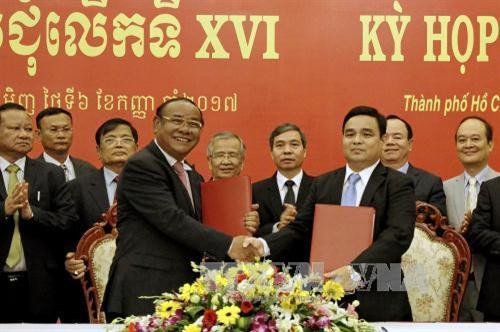 Thượng tướng Lê Chiêm, Thứ trưởng Bộ Quốc phòng, Chủ tịch Ủy ban Chuyên trách Chính phủ Việt Nam (phải) và Đại tướng Pol Saroun, Tổng Tư lệnh Quân đội Hoàng gia Campuchia, Chủ tịch Ủy ban Chuyên trách Chính phủ Campuchia trao đổi bản ký kết biên bản Kỳ họp lần thứ XVI. Ảnh : Thế Anh-TTXVN