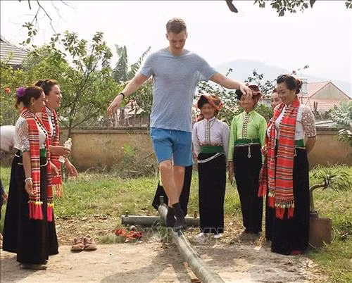 Du khách nước ngoài đi cầu kiều tại Lễ hội Hết chá. Ảnh: Nguyễn Cường - TTXVN