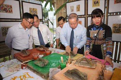 Ông Phan Ngọc Thọ - Chủ tịch UBND tỉnh Thừa Thiên-Huế (thứ 2 từ phải sang) trải nghiệm làm tranh dân gian Đông Hồ tại triển lãm. Ảnh: Hồ Cầu-TTXVN