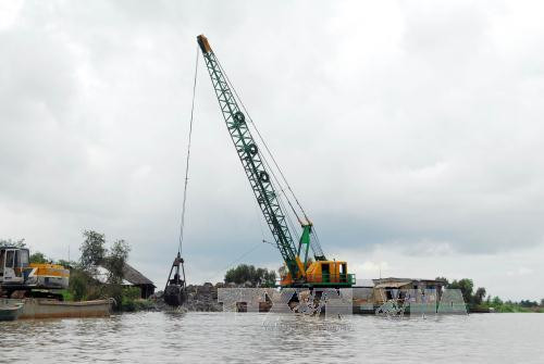 Các phương tiện thi công gia cố bờ bao tại Kênh 79, xã Tân Lập, huyện Tân Hưng, Long An. Ảnh: Mạnh Linh – TTXVN