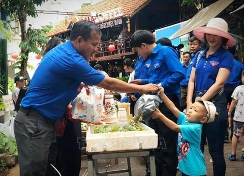 Hoạt động đổi rác thải nhựa lấy rau sạch. Ảnh: Tuấn Anh – TTXVN