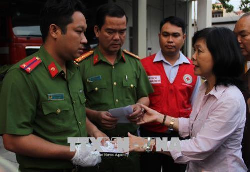 Bà Đặng Hồng Nhung, đại diện Trung ương Hội Chữ thập đỏ Việt Nam đã trao tiền hỗ trợ cho chiến sĩ công an phòng cháy chữa cháy bị thương trong khi chữa cháy sáng 23/3. Ảnh: Xuân Dự - TTXVN
