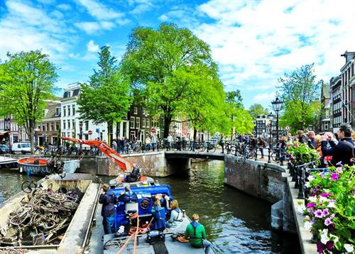 4: Là số mét mà Schiphol - sân bay Amsterdam - nằm dưới mực nước biển. Ảnh: NACO. 165: Là tổng số kênh đào ở Amsterdam với tổng chiều dài lên tới khoảng 100 km. Trong đó, khu vực kênh được đào từ thế kỷ 17 ở Singelracht đã trở thành Di sản Thế giới của UNESCO vào năm 2010. Ảnh: Thewallpaper. 1.281: Đó là tất cả số cầu ở Amsterdam, trong đó 80 cầu nằm trong trung tâm thành phố. Magere Brug - còn được gọi là cầu Skinny - là cây cầu nổi tiếng nhất. Ngoài ra, nơi kênh đào Reguliersgracht và Herengracht giao nhau chính là cầu Bridge of 15 Bridges. Nếu tìm được vị trí lý tưởng, đặc biệt vào ban đêm, bạn có thể nhìn thấy những nhịp cầu có 15 mái vòm được chiếu sáng lung linh. Ảnh: Traveltipy. 1.515: Là số lượng quán bar và cà phê ở Amsterdam. Đây là thiên đường dành cho những người mê bia Heineken. Ảnh: Panoramio. 2.500: Amsterdam có khoảng 2.500 nhà thuyền neo đậu trên khắp các con kênh. Hầu hết trong số đó là nơi cư trú của người dân, một số khác dành sẵn cho du khách. Đáng chú ý, có cả một nhà thuyền chỉ dành riêng cho mèo, đó là De Poezenboot trên kênh Singel. Ảnh: Hotel Cornelisz. 25.000: Hàng năm, có khoảng 25.000 chiếc xe đạp kết thúc “cuộc đời” mình ở các kênh đào của Amsterdam. Vì thế, ở đây cũng đã xuất hiện một nghề khá độc: nghề vớt xe đạp. Theo một thợ “câu” xe đạp ở Amsterdam, khoảng 20% số xe “cuốn theo chiều gió”, 80% còn lại là do người dân cố tình ném xuống. Ảnh: Dutchamsterdam. 881.000: Thật lạ là trong khi cư dân thành phố chỉ có khoảng 799.400 người, Amsterdam có đến khoảng 881.000 chiếc xe đạp. Một số ước tính cho biết cứ mỗi năm lại có khoảng 100.000 chiếc xe bị mất cắp. Đây cũng là thứ bị mất trộm nhiều nhất tại thủ đô Hà Lan mà không phải tiền bạc hay tài sản vĩ đại gì khác. Ảnh: Michell Zappa/Flickr . 11.000.000: Là số lượng trụ gỗ ước tính nâng đỡ cho các tòa nhà ở Amsterdam. Mọi cấu trúc trong thành phố đều sử dụng những trụ gỗ dài từ 15-20 mét chôn xuyên qua bùn và cố định trong một lớp cát dày trung bình 11 m. Một ngôi nhà điển hình ở đây thường có khoảng 10 cây gỗ giúp bảo vệ nó khỏi lớp bùn lầy, trong khi nhà ga trung tâm Central Station phải cần đến gần 9.000 trụ. Ảnh: Erik Tjallinks/Flickr. 20.000.000: Là lượng khách hàng năm tới thăm Amsterdam, nhiều gấp khoảng 20 lần dân số địa phương. May mắn thay, bạn vẫn có thể tìm thấy cho mình những nơi yên tĩnh để thư giãn. Ảnh: National Geographic. 4: Là số mét mà Schiphol - sân bay Amsterdam - nằm dưới mực nước biển. Ảnh: NACO. 165: Là tổng số kênh đào ở Amsterdam với tổng chiều dài lên tới khoảng 100 km. Trong đó, khu vực kênh được đào từ thế kỷ 17 ở Singelracht đã trở thành Di sản Thế giới của UNESCO vào năm 2010. Ảnh: Thewallpaper. 1.281: Đó là tất cả số cầu ở Amsterdam, trong đó 80 cầu nằm trong trung tâm thành phố. Magere Brug - còn được gọi là cầu Skinny - là cây cầu nổi tiếng nhất. Ngoài ra, nơi kênh đào Reguliersgracht và Herengracht giao nhau chính là cầu Bridge of 15 Bridges. Nếu tìm được vị trí lý tưởng, đặc biệt vào ban đêm, bạn có thể nhìn thấy những nhịp cầu có 15 mái vòm được chiếu sáng lung linh. Ảnh: Traveltipy. 1.515: Là số lượng quán bar và cà phê ở Amsterdam. Đây là thiên đường dành cho những người mê bia Heineken. Ảnh: Panoramio. 2.500: Amsterdam có khoảng 2.500 nhà thuyền neo đậu trên khắp các con kênh. Hầu hết trong số đó là nơi cư trú của người dân, một số khác dành sẵn cho du khách. Đáng chú ý, có cả một nhà thuyền chỉ dành riêng cho mèo, đó là De Poezenboot trên kênh Singel. Ảnh: Hotel Cornelisz. 25.000: Hàng năm, có khoảng 25.000 chiếc xe đạp kết thúc “cuộc đời” mình ở các kênh đào của Amsterdam. Vì thế, ở đây cũng đã xuất hiện một nghề khá độc: nghề vớt xe đạp. Theo một thợ “câu” xe đạp ở Amsterdam, khoảng 20% số xe “cuốn theo chiều gió”, 80% còn lại là do người dân cố tình ném xuống. Ảnh: Dutchamsterdam. 881.000: Thật lạ là trong khi cư dân thành phố chỉ có khoảng 799.400 người, Amsterdam có đến khoảng 881.000 chiếc xe đạp. Một số ước tính cho biết cứ mỗi năm lại có khoảng 100.000 chiếc xe bị mất cắp. Đây cũng là thứ bị mất trộm nhiều nhất tại thủ đô Hà Lan mà không phải tiền bạc hay tài sản vĩ đại gì khác. Ảnh: Michell Zappa/Flickr . 11.000.000: Là số lượng trụ gỗ ước tính nâng đỡ cho các tòa nhà ở Amsterdam. Mọi cấu trúc trong thành phố đều sử dụng những trụ gỗ dài từ 15-20 mét chôn xuyên qua bùn và cố định trong một lớp cát dày trung bình 11 m. Một ngôi nhà điển hình ở đây thường có khoảng 10 cây gỗ giúp bảo vệ nó khỏi lớp bùn lầy, trong khi nhà ga trung tâm Central Station phải cần đến gần 9.000 trụ. Ảnh: Erik Tjallinks/Flickr. 20.000.000: Là lượng khách hàng năm tới thăm Amsterdam, nhiều gấp khoảng 20 lần dân số địa phương. May mắn thay, bạn vẫn có thể tìm thấy cho mình những nơi yên tĩnh để thư giãn. Ảnh: National Geographic.