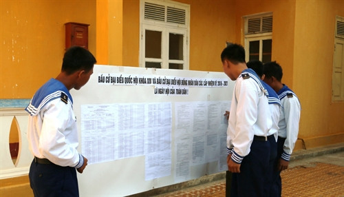 Các chiến sỹ trẻ trên đảo Trường Sa lần đầu tham gia bầu cử đang xem niêm yết danh sách cử tri. Ảnh: Hứa Chung – TTXVN Các chiến sỹ trẻ trên đảo Trường Sa lần đầu tham gia bầu cử đang xem niêm yết danh sách cử tri. Ảnh: Hứa Chung – TTXVN