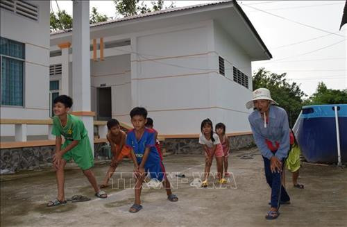 Bà Trần Thị Kim Thia hướng dẫn trẻ khởi động trước khi xuống bể học bơi. Ảnh: Chương Đài - TTXVN Bà Trần Thị Kim Thia hướng dẫn trẻ khởi động trước khi xuống bể học bơi. Ảnh: Chương Đài - TTXVN