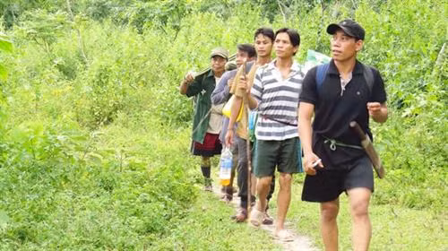 Xã đội trưởng Đinh Tân (người đi đầu) và các thành viên an ninh xã tuần tra bảo vệ rừng.