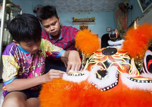 Anh Lê Văn Hiền kiểm tra công đoạn gắn lông cho đầu lân. Ảnh: Hồng Đạt - TTXVN Anh Lê Văn Hiền kiểm tra công đoạn gắn lông cho đầu lân. Ảnh: Hồng Đạt - TTXVN