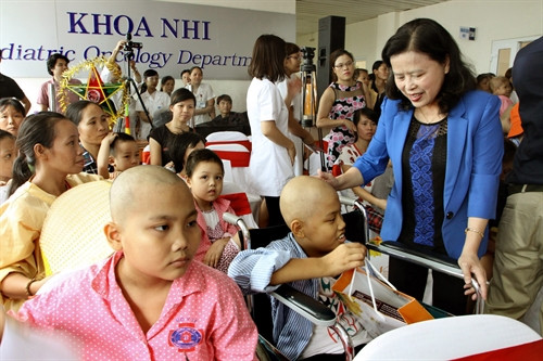 PGS.TS Nguyễn Thị Xuyên, nguyên Thứ trưởng Bộ Y tế, Chủ tịch Tổng hội Y học Việt Nam, Chủ tịch Quỹ Ngày mai tươi sáng tặng quà cho bệnh nhi ung thư. Ảnh: Dương Ngọc – TTXVN