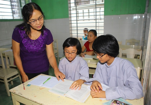 Cô giáo Lê Thị Kim Tiến hướng dẫn các em học bài Cô giáo Lê Thị Kim Tiến hướng dẫn các em học bài
