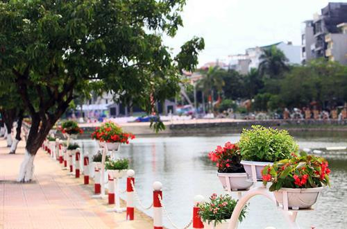 Dọc phố đi bộ Trịnh Công Sơn có hai hồ điều hòa tự nhiên có cây, hàng rào sắt và trang trí bằng nhiều bình hòa rực rỡ màu sắc. Ảnh: Quang Quyết-TTXVN