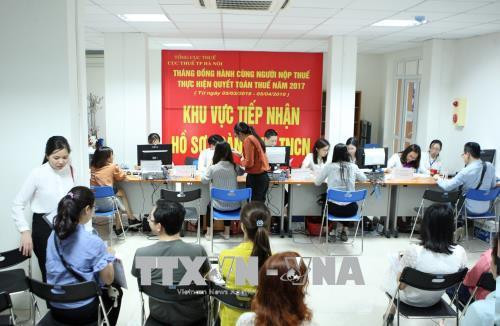 Tổng đại lý thuế tham gia hỗ trợ người nộp thuế thực hiện quyết toán thuế tại Văn phòng Cục thuế Hà Nội. Ảnh: Hoàng Hùng - TTXVN Tổng đại lý thuế tham gia hỗ trợ người nộp thuế thực hiện quyết toán thuế tại Văn phòng Cục thuế Hà Nội. Ảnh: Hoàng Hùng - TTXVN