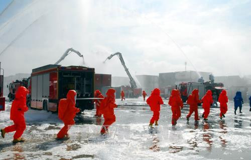 Diễn tập tình huống cơn bão số 13 có cường độ rất mạnh gây ảnh hưởng trực tiếp đến các tàu hàng đang neo đậu tại Tân Cảng Cát Lái, Quận 2. Hàng hoá trong các container bị xô lệnh, đổ vỡ, sau khi sắp xếp vào kho bãi, hoá chất trong các container bị rò rỉ và gây cháy. Ảnh: Mạnh Linh-TTXVN