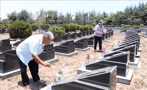 Ông Huỳnh Đồng (nguyên Trung đội trưởng Trinh sát – Đoàn 10) và bà Phạm Thị Nhung (cán bộ y tá Đoàn 10) thắp nhang cho các đồng đội tại Nghĩa trang Liệt sĩ Rừng Sác. Ảnh: Xuân Khu - TTXVN