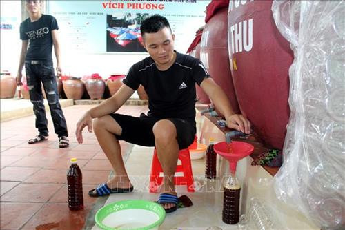 Cho nước mắm Sầm Sơn vào chai để bán cho khách hàng. Ảnh: Nguyễn Nam-TTXVN Cho nước mắm Sầm Sơn vào chai để bán cho khách hàng. Ảnh: Nguyễn Nam-TTXVN