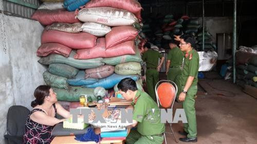 Lực lượng chức năng làm việc với chủ cơ sở sản xuất cà phê bẩn. Ảnh: TTXVN phát