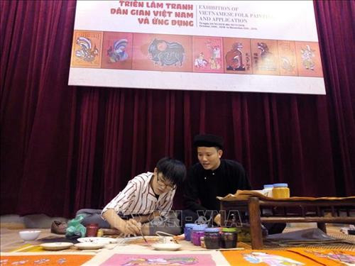 Trình diễn tranh dân gian tại triển lãm. Ảnh: TTXVN