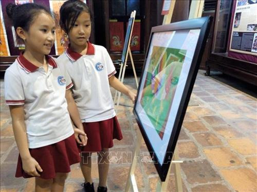 Học sinh tham quan triển lãm tranh dân gian trước giờ khai mạc. Ảnh: TTXVN