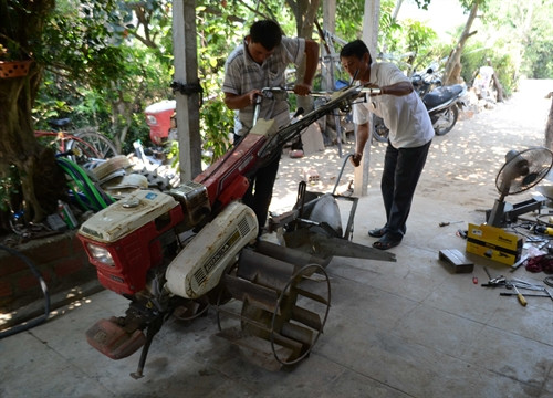 Ông Huỳnh Tiển (phải) cùng con trai chế tạo, lắp ráp máy lên luống. Ông Huỳnh Tiển (phải) cùng con trai chế tạo, lắp ráp máy lên luống.