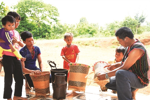 Ông Điểu M’rưng giải thích cho con cháu nghe ý nghĩa của những họa tiết trên các loại gùi Ông Điểu M’rưng giải thích cho con cháu nghe ý nghĩa của những họa tiết trên các loại gùi