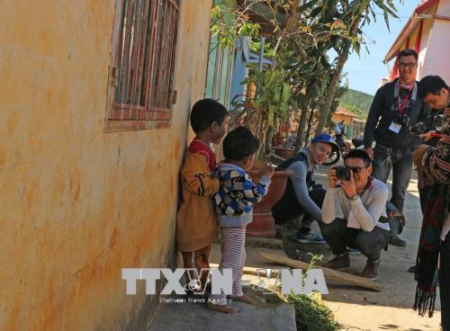 Một nhóm du khách trẻ chụp hình các em nhỏ trong buôn làng. Ảnh: Nguyễn Dũng – TTXVN Một nhóm du khách trẻ chụp hình các em nhỏ trong buôn làng. Ảnh: Nguyễn Dũng – TTXVN