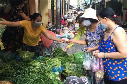 Nhiều người dân vẫn mua bán hàng hóa tại khu vực hẻm 430 Cách Mạng Tháng Tám, Phường 11, Quận 3 (từ Cách Mạng Tháng Tám đến cuối hẻm ra đường Trần Văn Đang - Cống Bà Xếp) bất chấp việc thông báo của chính quyền địa phương trước đó (ảnh chụp lúc 6h30, sáng 28/3). Ảnh: Thanh Vũ - TTXVN