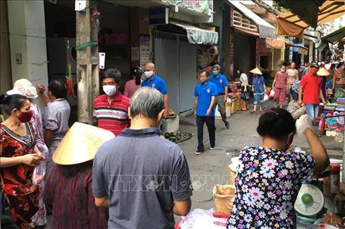 Lực lượng Cựu chiến Binh địa phương đã có mặt nhắc nhở giải tán tình trạng buôn bán tự phát tại khu vực hẻm 430 Cách Mạng Tháng Tám, Phường 11, Quận 3 (ảnh chụp 7 giờ, sáng 28/3). Ảnh: Thanh Vũ - TTXVN