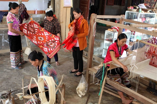 Chị em đồng bào dân tộc Thái ở làng nghề dệt thổ cấm Châu Tiến, Quỳ Châu (Nghệ An) cùng nhau chia sẻ kinh nghiệm làm các sản phẩm thổ cẩm.