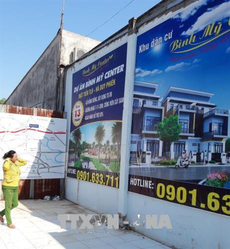 Biển hiệu quảng cáo "dự án" đất nền Bình Mỹ Center Tỉnh lộ 9, huyện Củ Chi. Ảnh: Trần Xuân Tình - TTXVN Biển hiệu quảng cáo "dự án" đất nền Bình Mỹ Center Tỉnh lộ 9, huyện Củ Chi. Ảnh: Trần Xuân Tình - TTXVN