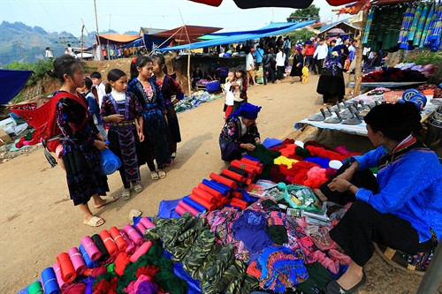Những phụ nữ người Mông mang theo con xuống chợ. Các nguyên liệu phục vụ dệt thổ cẩm được bày bán nhiều tại chợ. Những phụ nữ người Mông mang theo con xuống chợ. Các nguyên liệu phục vụ dệt thổ cẩm được bày bán nhiều tại chợ.